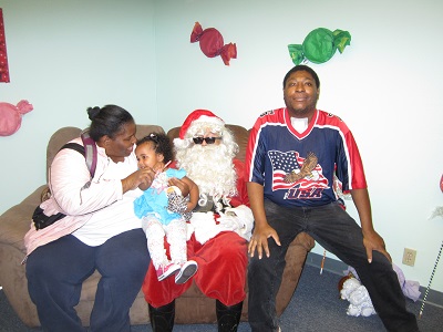 A family sittng with Santa on a couch